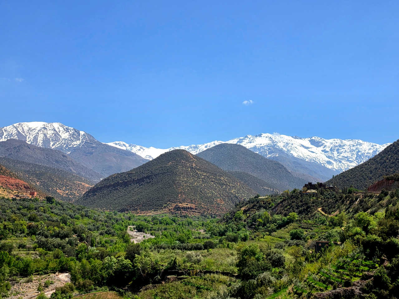 Snow-capped High Atlas peaks rising above a green valley